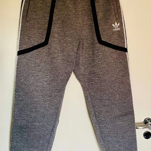 Grå Adidas mjukisbyxor stl M - Grå ovanliga Adidas byxor, stl M, verkar inte mycket använda!