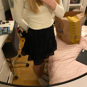 Kjol - Svart kjol med blommönster av håll  Aldrig använd 