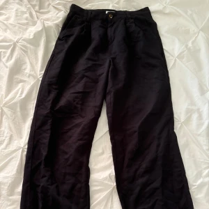 Högmidjade kostymbyxor  - Svarta kostymbyxor som sitter lågmidjat 