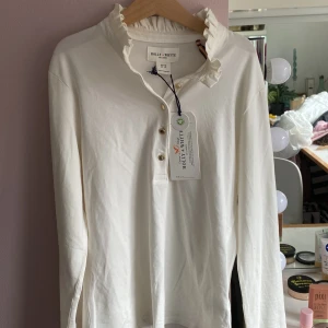 Crémevit oanvänd tröja -  Jättefin gullig volang krage och guldiga små knappar, säljer den för att den aldrig har kommit till användning. 🩷