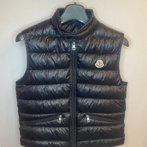 Moncler Gui Down Vest - Riktigt bra skick utan defekter. Den är som ny och allt og finns med. Kvitto finns från Miinto. Färg svart i storlek 3.