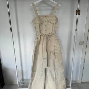 Jumpsuit Byxdress - Säljer en byxdress med vida ben i storlek 40 EU! Jumpsuiten har ett midjebälte som ger väldigt fin form!   Sparsamt använd   (Köparen står för frakt)