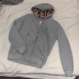 Grå huvtröja med dragkedja - Grå burrberry zip hoodie. Skick 10/10 knappt använd