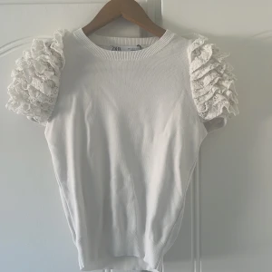 Vit tröja med volanger  - En vit tröja med volanger vid axlarna. Den är från zara i strl S