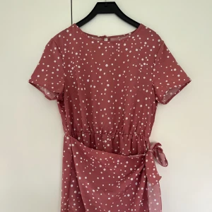 Rosa/vit sommarklänning - Rosa, vitprickig omlott sommarklänning💗💗 Finns ingen lapp och minns inte var jag köpt, men storlek XS/S Endast använd fåtal gånger så mycket bra skick🥰