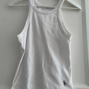 Linne Sporty & Rich - Linne Sporty & Rich  https://www.sportyandrich.com/products/src-ribbed-tank-top-white?_pos=31&_sid=c7151af69&_ss=r  Ribbad vit Lös passform Strl M Ord 702kr