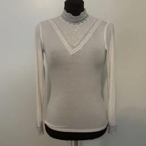 Vit tunn tröja - En fin tunn långärmad med fint mönster vid kragen och handlederna. Pris + frakt