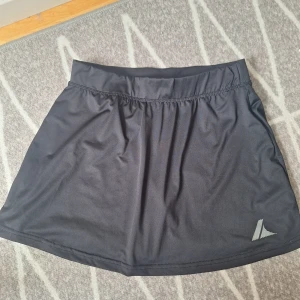 Svart kjol - Jättefin svart kjol. Är i träningsmaterial med inbyggda skjorts i. Säljer då jag själv längden blev lite för kort ( bild 2 ). Lägger sig jättefint🖤