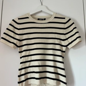 Randig kroppad tröja  - Säljer denna randiga, kroppade tröjan från Gina tricot i stl L är helt ny och aldrig använd och prislappen sitter kvar men säljer denna eftersom att jag aldrig använder den