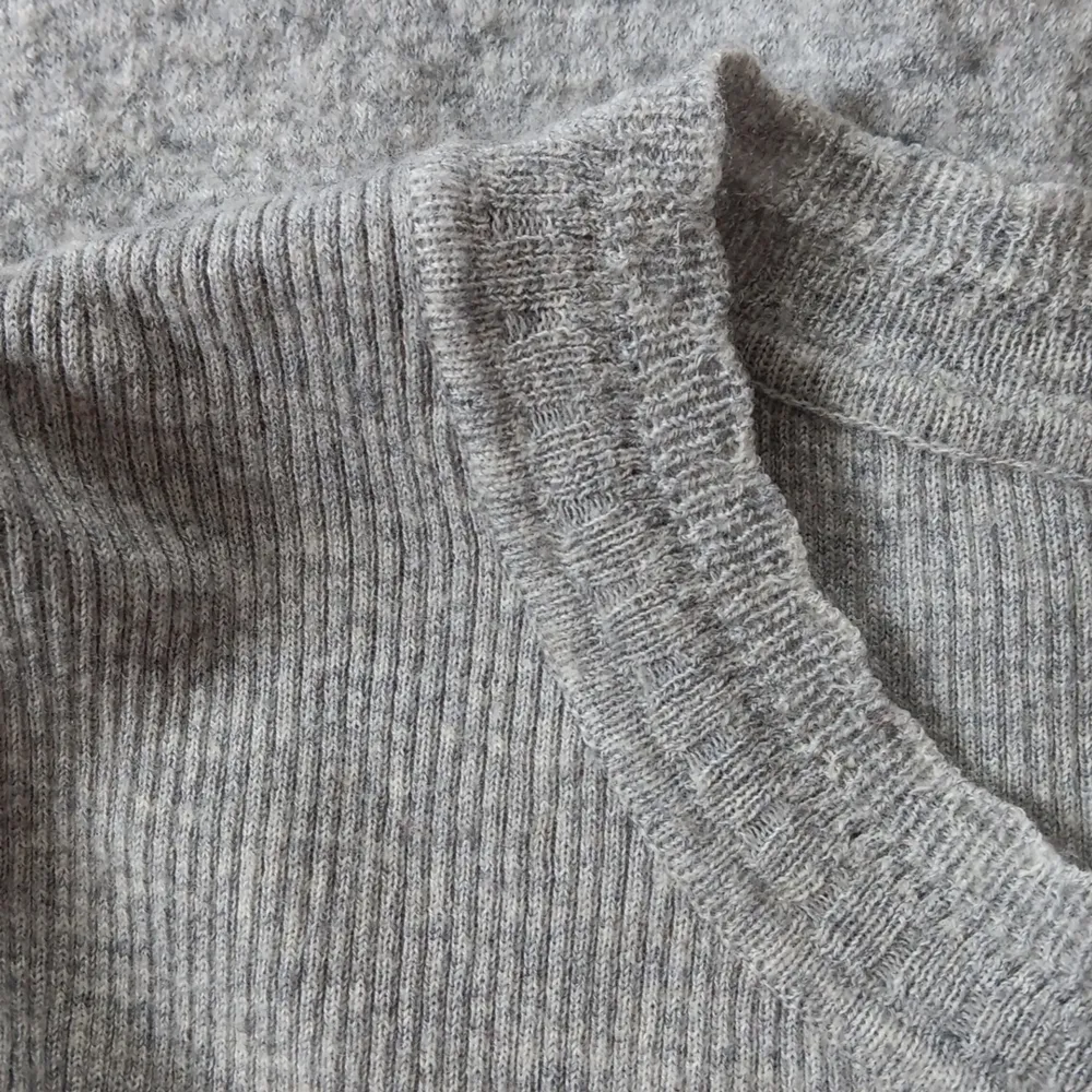 Grå stickad tröja/tunika från H&M. Gjort av ylle och är jättemjuk, skön och varm. Är i använt skick. Stickat.
