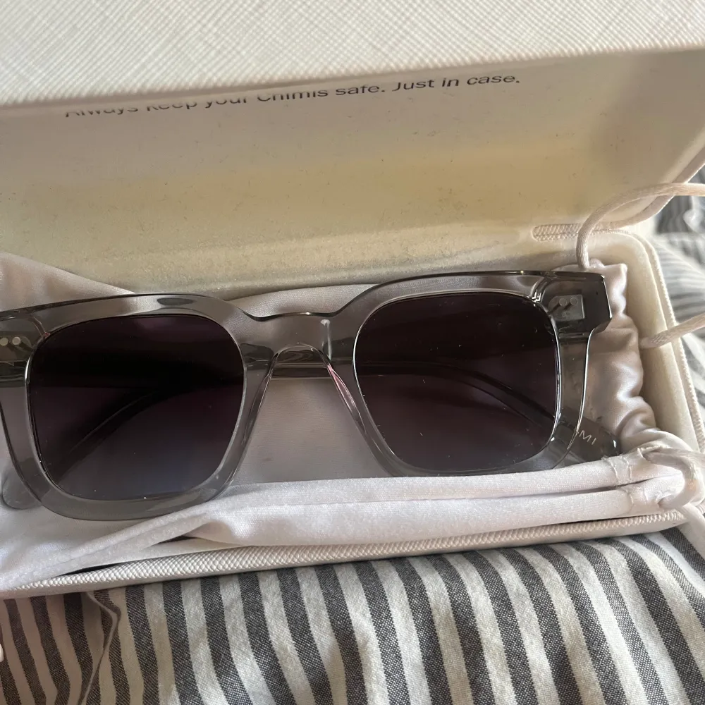 Gråa Solglasögon från Chimi. Använd fåtal gånger och ser ut som nya. Modellen är 04 och normal i storlek. Duk till glaset, glasögonpåse och fodral tillkommer.. Accessoarer.