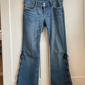 Unika Custom made jeans från hm😍. De är i mycket bra skick‼️, med snörning långt ner på benen och broderade fickor.  Bara skriva om du har frågor🥰 Midjemått rakt över:40cm Innerben:70cm 