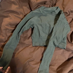 Croppad ribbad träningströja - En jättefin långärmad, croppad och ribbad tshirt. Säljer pågrund av att jag inte använder längre tyvärr