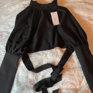 Hanna Schönberg topp  - Från Hanna Schönbergs kollektion, oanvänd med lapp kvar.  Halvt öppen rygg.  Här är modellen: https://www.na-kd.com/sv/produkter/topp-svart-11