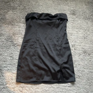 Svart kort klänning - Svart klänning med en liten slits fram på vänster ben. I storlek 40 från ginatricot. Aldrig använd så den är som ny!
