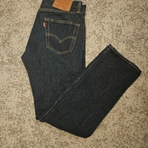 Levis Jeans 501  - Säljer nu mina fina Levis jeans som inte längre passar mig. De har alltid blivit behandlade bra och just därför är de i så bra skick. Den enda nackdelen är ett litet slitage som ni ser på bild 3. Fraktar inom 24h📦 Storlek W28 L32. Skick 7,5/10
