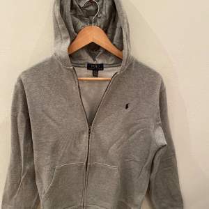 Polo Ralph Lauren Zip hoodie i mycket bra skick 8,5/10. Storleken är 18-20y 170cm XL/TG. Den är grå. Nypris 1100kr