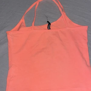 Topp - En neonrosa topp från Sinsay som aldrig använts. Banden är korsade så man kan välja att korsa fram eller bak🪷
