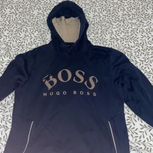 Hugo boss tröja - Hugo boss tröja, navy blå/guld. Storlek M. Bra skick. Finns ett litet fel me tröjan. Hör av er vid intresse så kan pris och felet diskuteras :)