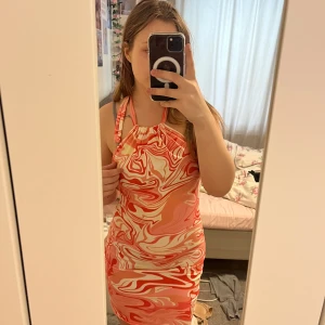 Färg glad klänning  - Klänningen har öppen rygg och justerbar vid halsen, är inte för kort och inte för lång