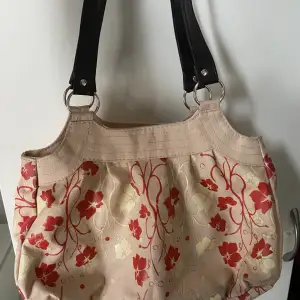 Superfin mellanstor blommig handväska med bruna ”skinn” band. Köpt secondhand och är i superfint skick☺️