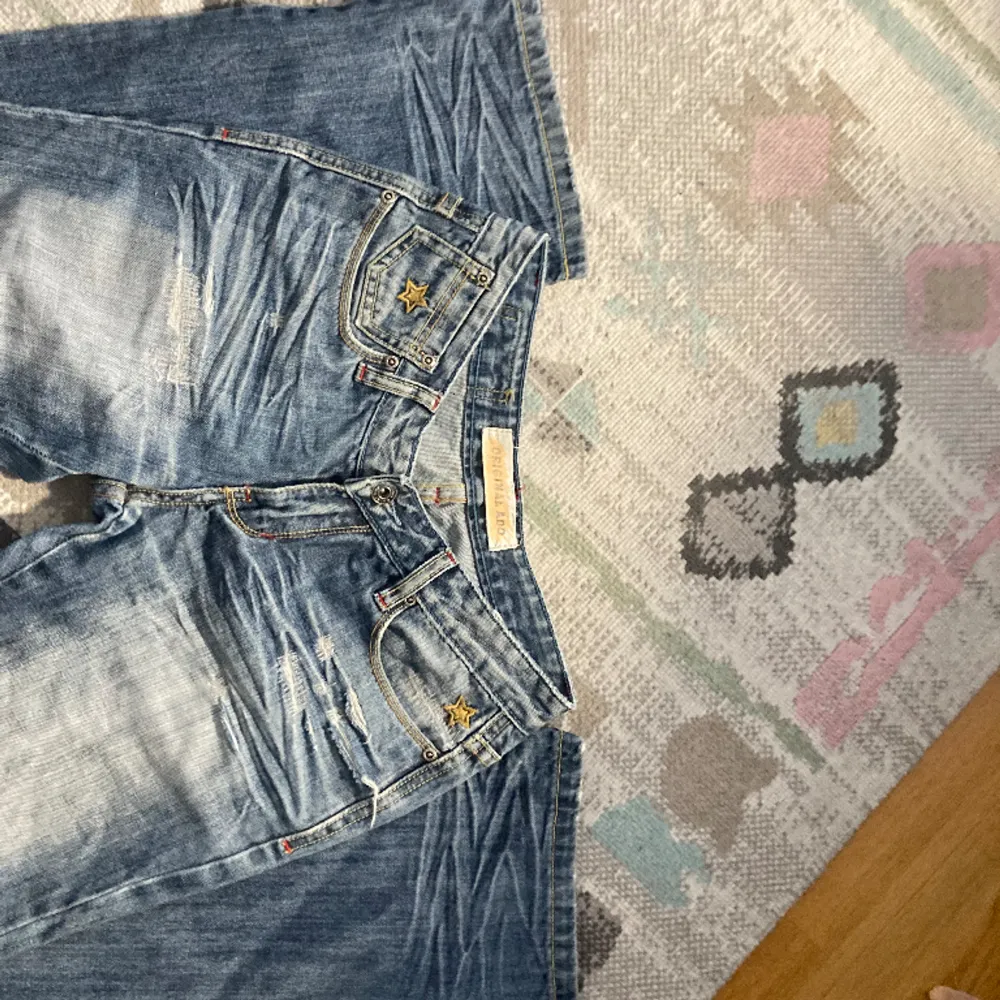 Säljer dessa lågmidjade jeans med stjärnor på💕 de e från mörkret original Ado. Midjemåttet är 38 cm över och 88 i innerbensmåttet.. Jeans & Byxor.