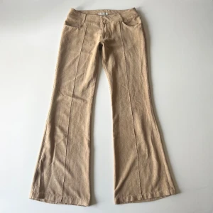 Beiga byxor - Vintage lågmidjade beige bootcut byxor i suede liknande material från Vero Moda. Midjemått: 76 cm. Innerbenslängd: 81 cm. Inga defekter. Modellen är 167 cm lång. Skriv privat för mer bilder och mått! 💕