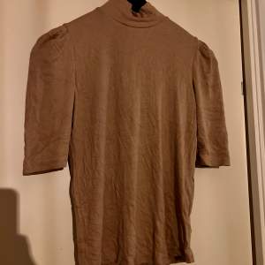 Stilren T-shirt från zara med låg polo, stretchig i materialet. Aldrig använd.