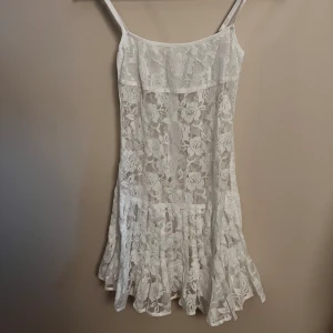 Frankies Bikinis klänning - Vit spetsklänning från frankies bikins. Helt ny med prislapp, aldrig använd. Jättefin klänning, säljer då den va tänkt till studenten men jag hittade en annan. Köpt för 1300kr+400(tull och frakt)