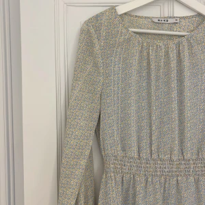 Blommig klänning  - Säljer nu min blå gul blommiga klänning ifrån NA-KD, perfekt till midsommar😍Den är i storlek XS men är väldigt stretchig, så skulle säga att den passar upp till storlek M! En ljusblå underklänning ingår också🙌🏻