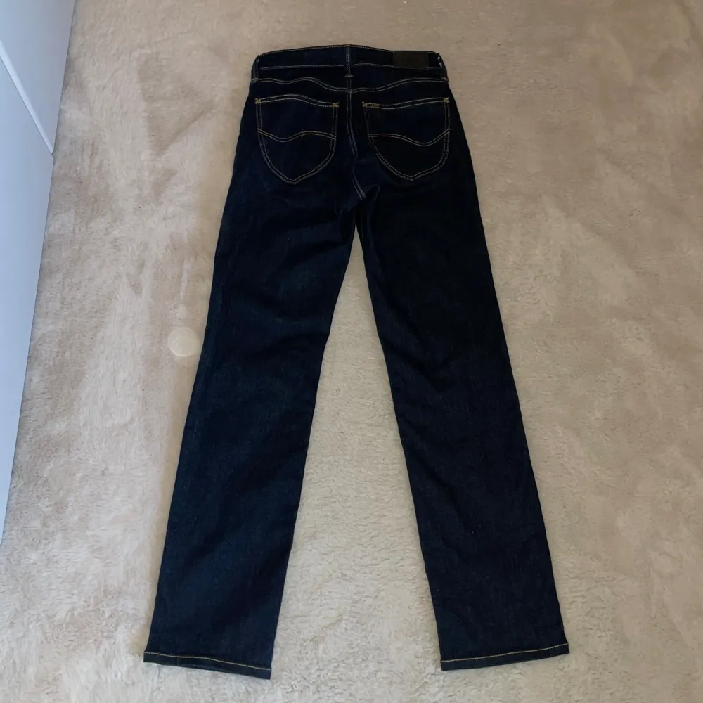 Straight passform. Mörkblå med gula sömmar. Längd ben:75 cm. Jeans & Byxor.