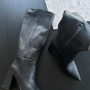 Stövlar med klack - Svarta stövlar med klack från NAKD, spetsig tå. Aldrig använda med levererades med en skada på klacken därav priset.   Nypris 1500kr