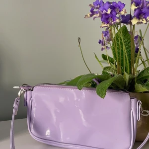 Snygg lila baguetteväska - Cool ljuslila baguettebag, rymlig och i vinyl-liknande material med textil på insidan. Y2K-stil och i mycket fint skick. 💜
