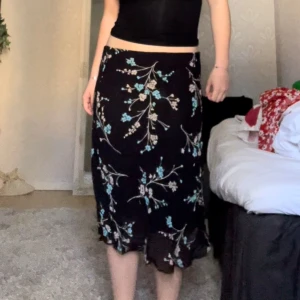 Svart blommog kjol - Köpte denna kjol på en secondhand för ett tag sen men den har inte kommit till användning. Storleken står inte på men passar mig som vanligtvis pendlar mellan 34/36/38. Skriv för fler bilder!🩷