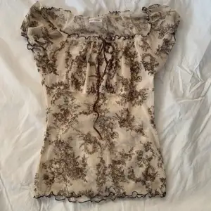 vintage top from the Japanese brand l'est rose. beige with brown flowers and a small bow, can be worn off shoulder. Mesh fabric see through. Japanese M which corresponds to xs-s 