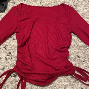 Röd topp  - En röd tight topp med snören på kanterna köpt från shein, den är i gott skick och stretchig