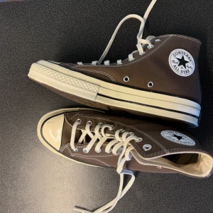 Bruna Converse skor - Säljer helt oanvända Converse skor som köpts i USA i Converse butik, då det går knappt att hitta dessa i Sverige. Skorna kan verka smutsiga pga damm, skorna är endast provade inomhus. Går att skanna kod på sista bilden för att se äkthet.