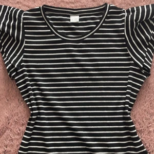 Fin svart och vit randig t-shirt💘 - En jätte fin t-shirt med volanger från lindex. Tröjan är endast använd 2-3 gånger. Det står att tröjan har stoelwk 158-164, antar att det är storlek S. 💘