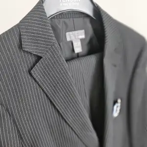 Säljer herr/kill kostym, svart med kritvita ränder. Inköpt på HM och har storlek 48 (M) på både kavaj och byxa.  Ingår slips och servett. Kom gärna med frågor eller bud!