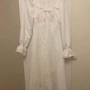 En vit lång klänning  - Oanvänd  Rätt i storlek Lång enda ner till knä till 165  Oanvänd 