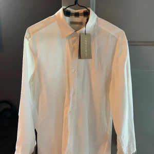 Burberry Shirt  - Monogram on cuffs and neck  9/10 condition, worn few times but no sign of wear.  Nypris: 2100kr