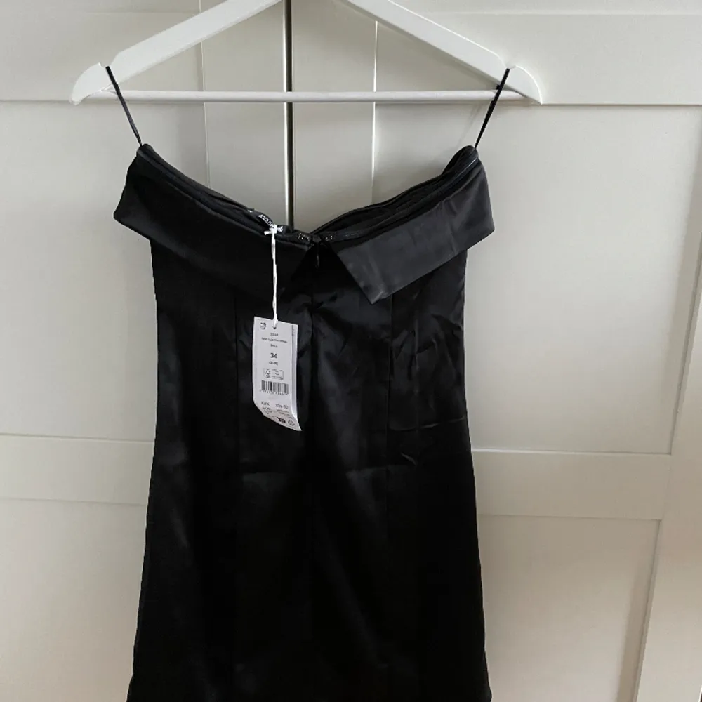 En superfin svart bandeau klänning med en liten slits från Ginatricot, aldrig använd med prislapp kvar! Nypris 399💗. Klänningar.