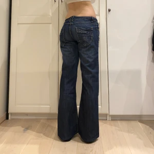 lågmidjade bootcut jeans💕 - midja 44 cm o innerben 75 cm ja e 170 för referens! rhinestones som bildar ett hjärta på ena fickan🩷
