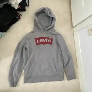 Grå hoodie från Levis, använd men i bra skick. Muddarna är lite slitna men inget som märks, storlek S