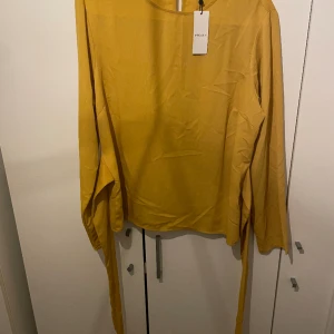 Blus  - Gul Blus från pieces i storlek xl. Knyte att knuta fram eller Bak som sitter fast i blusen  