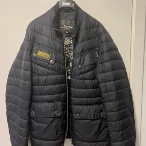Dunjacka från Barbour storlek XL (sitter som en L) - Dunjacka med storlek XL som sitter som en L från Barbour. Använd mindre än 10 gånger. Enda skråman som finns är på bild två vid ärmen. Rökfri. Nypris var 2700kr. Säljes för 500kr. 