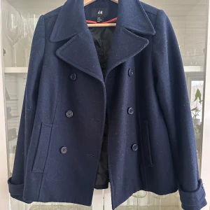 Marinblå kappa - Marinblå kappa från H&M i storlek 38. Liten i storleken så passar mer som en 34-36. Ser ut som den från Design By Si. Fint skick! 🩷🩷