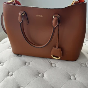Ralph lauren väska - Oanvänd Ralph lauren handväska. Helt ny. Dustbag ingår. Nypris var 3500kr.