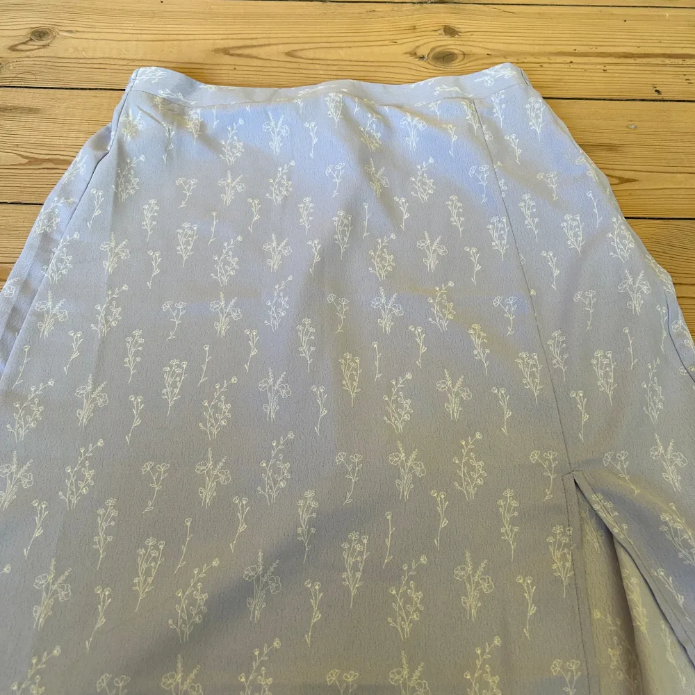 Säljer nu denna ljuslila kjol med blommönster som är köpt förra sommaren på veromoda💜, använd max 5 gånger. Midikjol med en slits vid benet🤍. Kjolar.