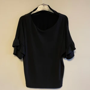 Blus  - Svart blus med volang ärmar 